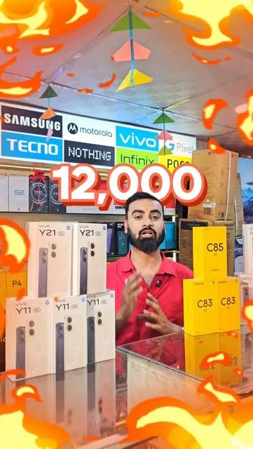 Shop owner behind a counter stacked with vivo and realme boxes